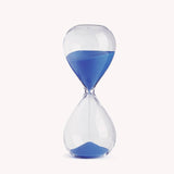 Classic hourglass with blue sand for focused productivity, dimensions 7.87" x 3.14", designed by Joe Mimran.