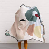 Colorful Arthur Throw blanket by Laurie Maun, designed for Slowdown Studio, showcasing abstract patterns and fringed edges.