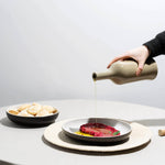Tan Brutto Oil Bottle pouring oil