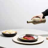 Tan Brutto Oil Bottle pouring oil