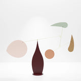 A modern abstract mobile made of aluminum blades and a stainless steel base, in shades of blue, beige, and brown.