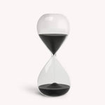 Desktop 30 minute hourglass in jet black with clear glass, designed for productivity and focus, dimensions 7.87" x 3.14".