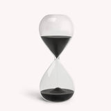 Desktop 30 minute hourglass in jet black with clear glass, designed for productivity and focus, dimensions 7.87" x 3.14".