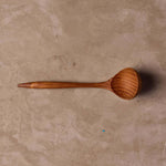 Teak sauce ladle on table