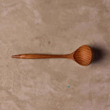 Teak sauce ladle on table
