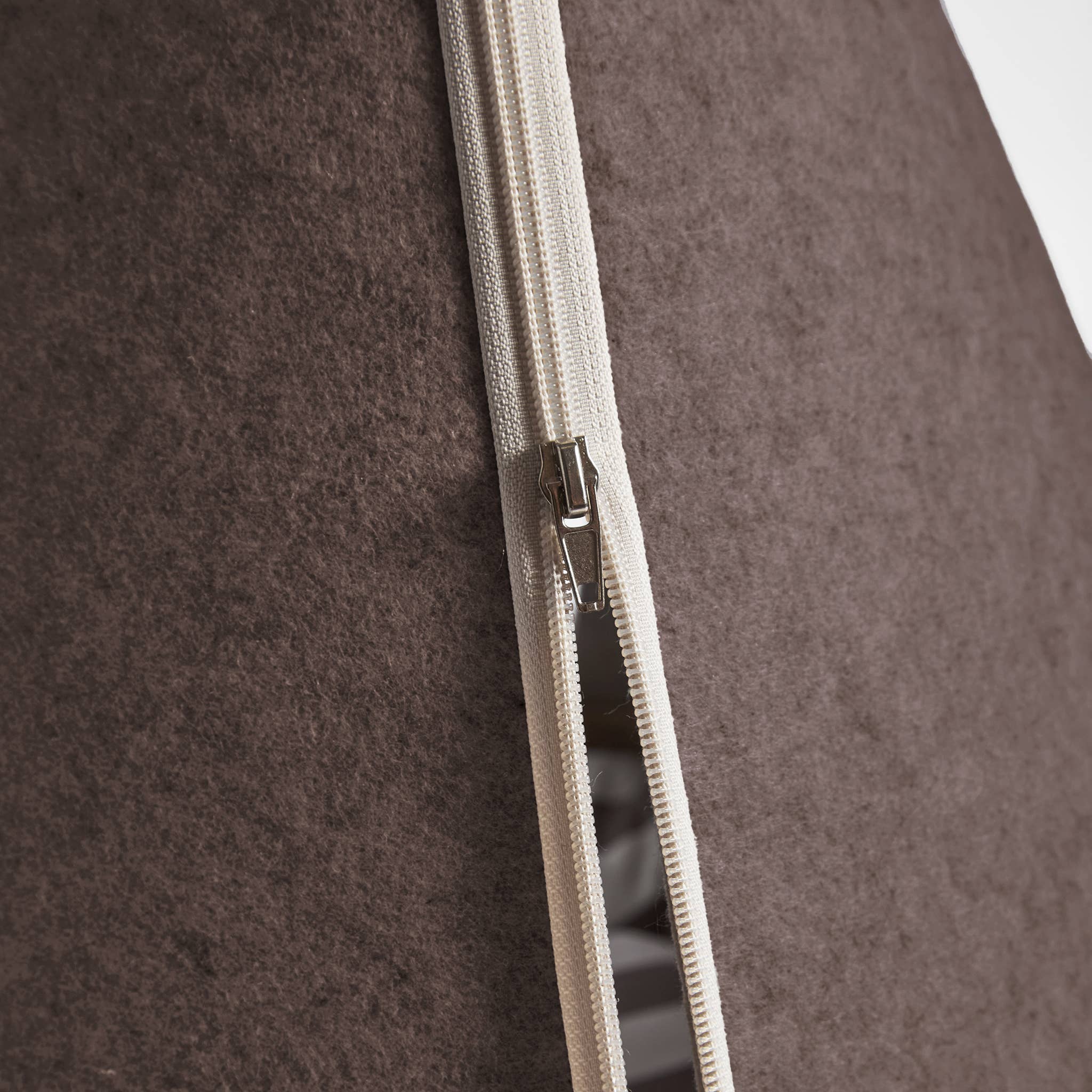 Close-up of a zipper on brown pet bed.