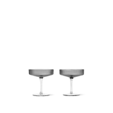 A pair of mouth-blown gray glass champagne saucers with a rippled surface design.