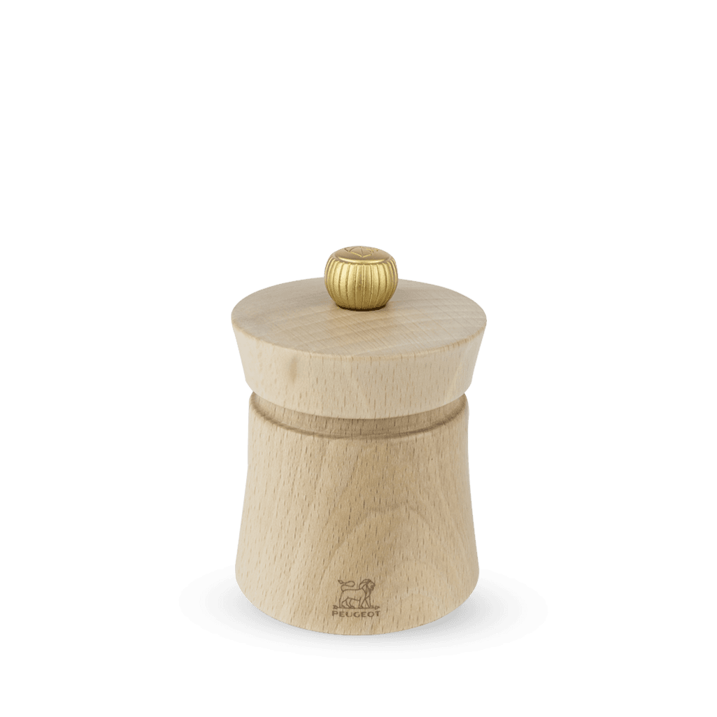A Peugeot Baya salt grinder made of natural beechwood with a stainless steel knob on top, displayed against a plain background.