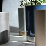 Hasami Porcelain small planters in glossy grey and dark blue with plants, showcasing modern and minimalist design.