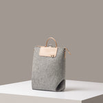 A stylish Bedford Merino Wool Felt Midi Backpack in light gray, displayed in a three-quarter view on a white base