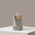 A light grey Bedford Merino Wool Felt Midi Backpack on a white base displayed in a side-view
