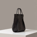 A charcoal Frankie Merino Wool Tote on a white base displayed in a side-view
