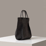 A charcoal Frankie Merino Wool Tote on a white base displayed in a side-view
