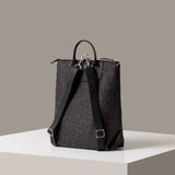 Rear view of a dark gray Bedford Merino Wool Felt Backpack by Graf Lantz featuring black shoulder straps