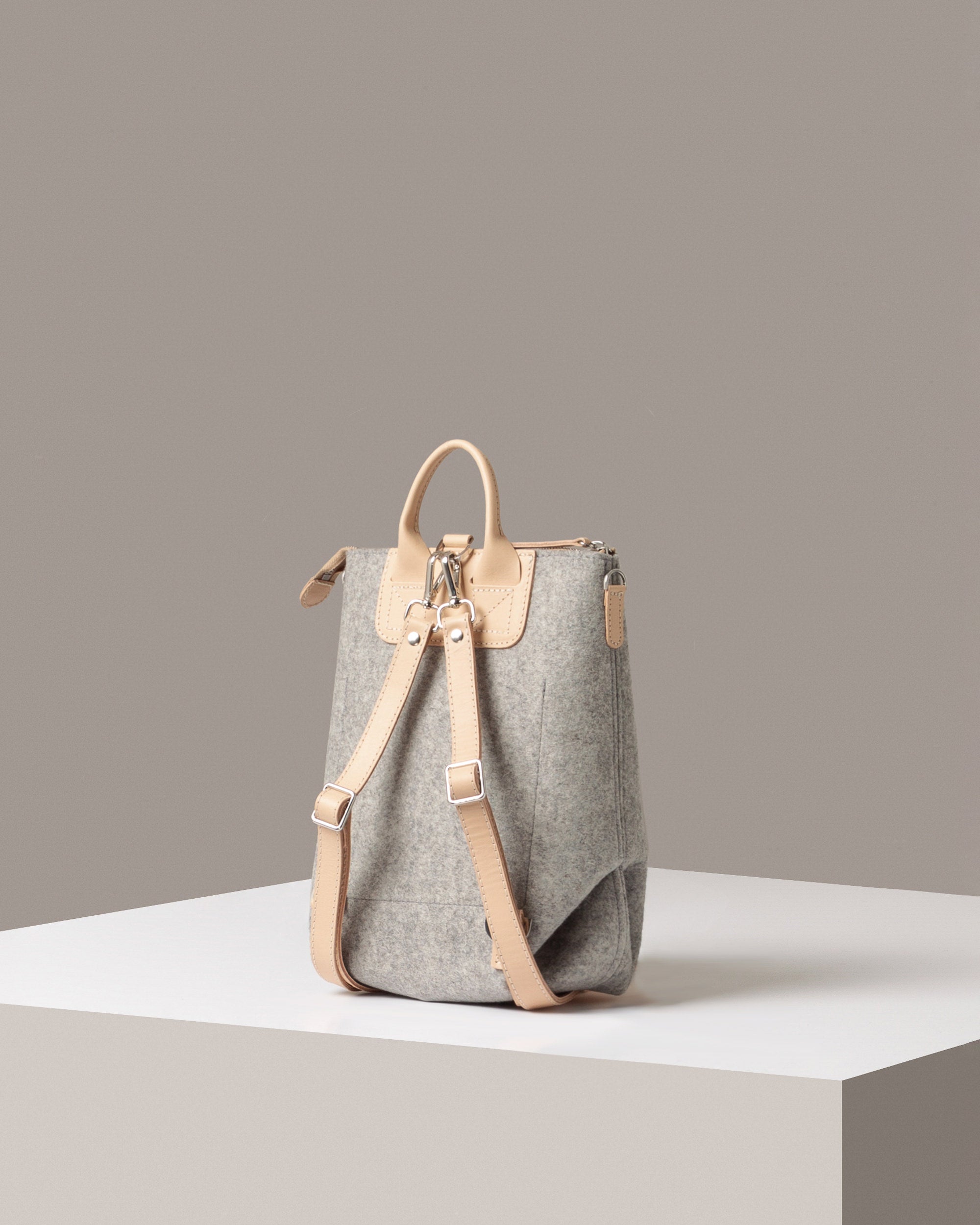 Rear view of a granite-colored Bedford Merino Wool Felt Midi Backpack by Graf Lantz featuring beige leather shoulder straps