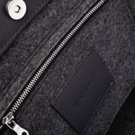 Interior view of Frankie Merino Wool Tote featuring a zippered felt pocket, black leather trim, and nickel hardware, highlighted in detail