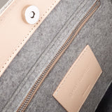 Interior view of a gray Frankie Merino Wool Felt Tote featuring a zippered felt pocket, beige leather trim, and nickel hardware, highlighted in detail