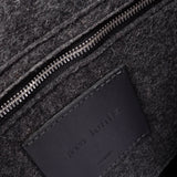 Interior view of dark grey Bedford Merino Wool Felt Backpack featuring a zippered felt pocket, black leather trim, and nickel hardware, highlighted in detail