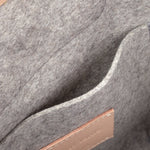 Interior view of a grey Bedford Merino Wool Felt Midi Backpack featuring an interior patch pocket and beige leather accents, highlighted in detail