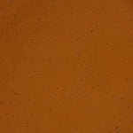 A closeup of a ceramic plate in a glossy caramel brown color with iron speckles throughout