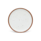 A dinner sized ceramic plate in a cool white color featuring iron speckles and an unglazed rim.
