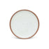 A dinner sized ceramic plate in a cool white color featuring iron speckles and an unglazed rim.