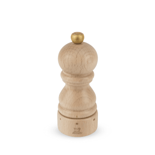 Wooden pepper grinder with gold top on a clear background
