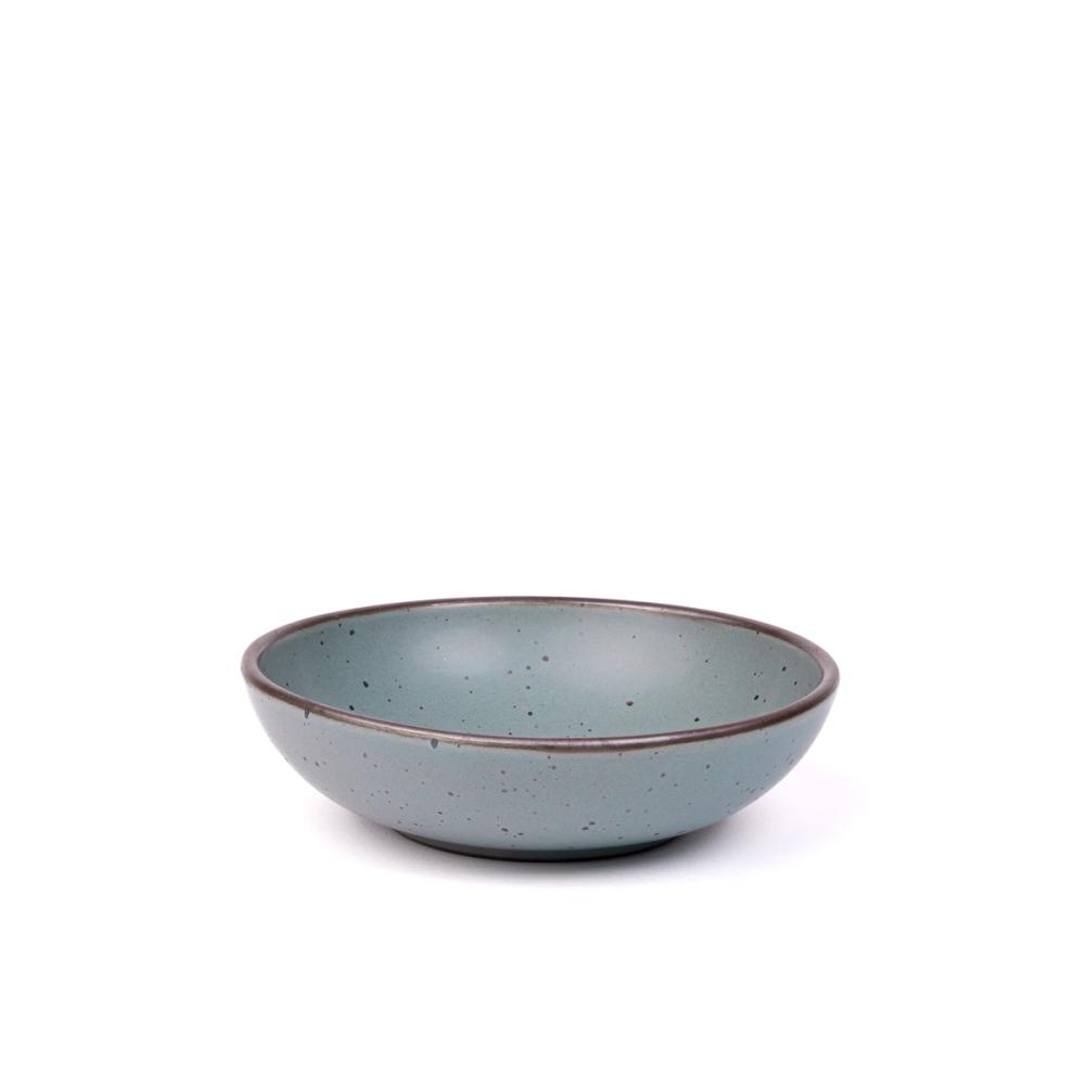 A dinner-sized shallow ceramic bowl in a blue-grey color featuring iron speckles and an unglazed rim