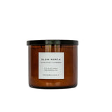 Brown candle with a black lid and white label on a white background