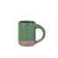 A medium sized ceramic mug with handle in a glossy emerald green color featuring iron speckles and unglazed rim and bottom base.