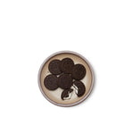 Oreos on a dessert sized ceramic plate in a warm pale brown color featuring iron speckles and an unglazed rim.