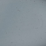 A closeup of a ceramic plate in a blue-grey color with iron speckles throughout