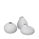 Three light grey ceramic vases of different shapes on a white background