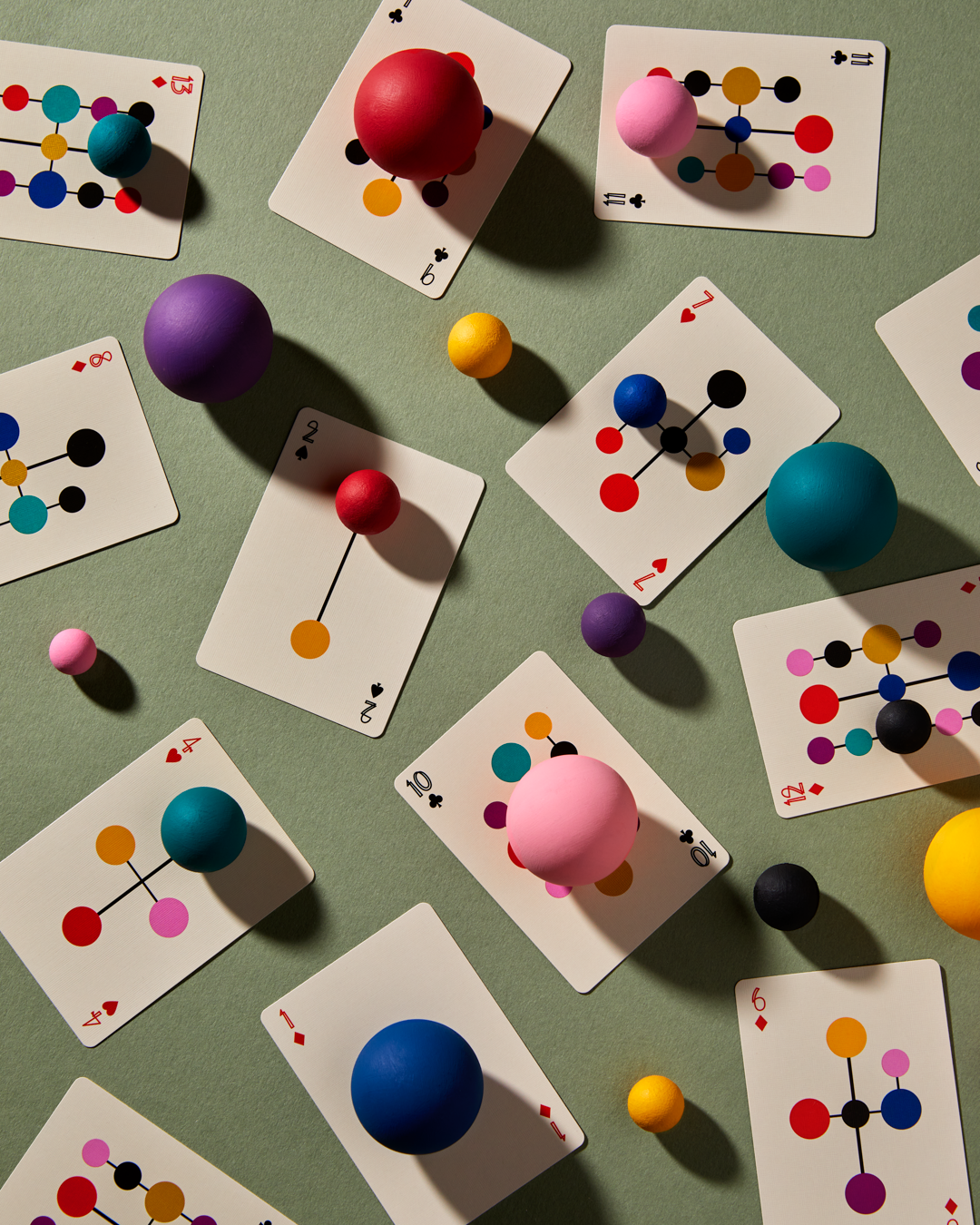 Playing cards with colorful geometric design on a green surface