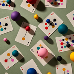 Playing cards with colorful geometric design on a green surface