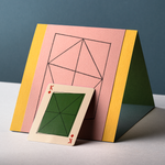 King of Diamonds playing card with green geometric shape laying against kite shaped geometric illustration against blue background