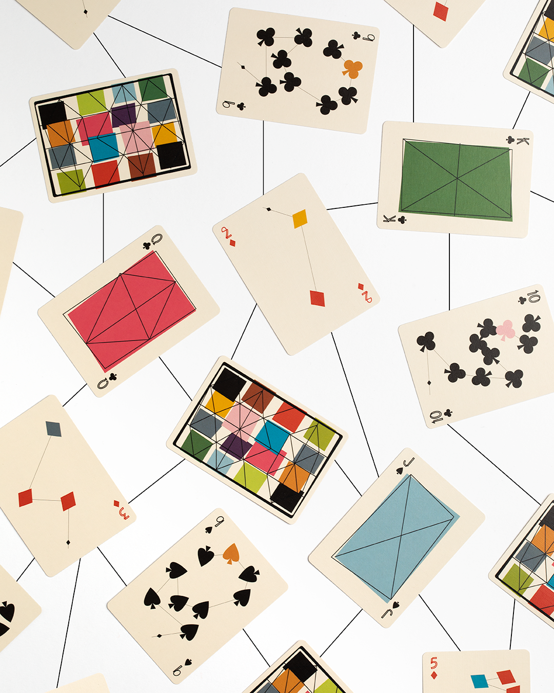 Playing cards with kite-like geometric designs on a white background 