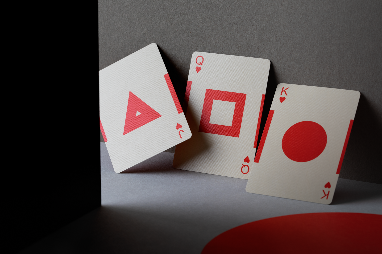 Three playing cards with unique symbols on a dark surface