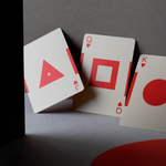 Three playing cards with unique symbols on a dark surface