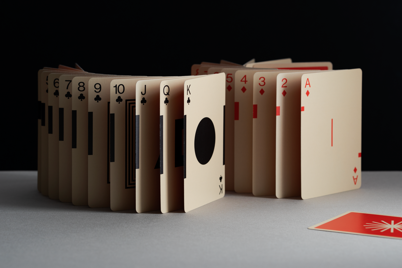 Playing cards arranged in a circular pattern on a gray surface with a black background