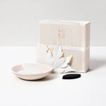 Paper incense leaves, small dish, and black mat on a white surface with a branded box.
