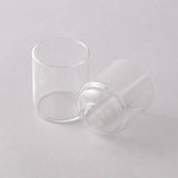 Two clear glass cups on a light gray background