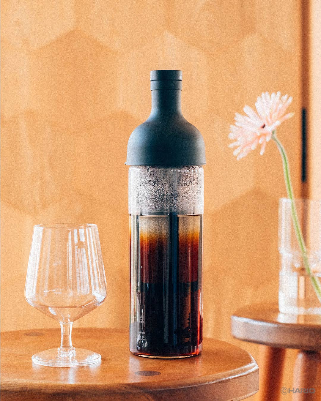 Bottle of cold brew coffee with a glass on a wooden table