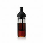 Bottle with a black cap and clear body containing a dark liquid on a white background
