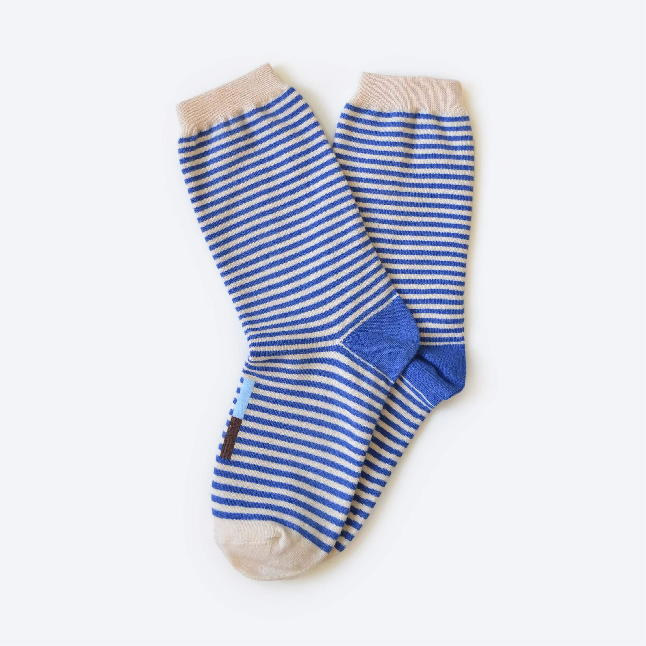 Pair of blue and white striped socks on a light gray background
