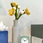 Daffodil Felt Flowers arranged in a tall grey vase on marble end table