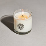 Candle in a glass jar with a logo on a gray background