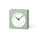 Light green square clock with a white face on a white background