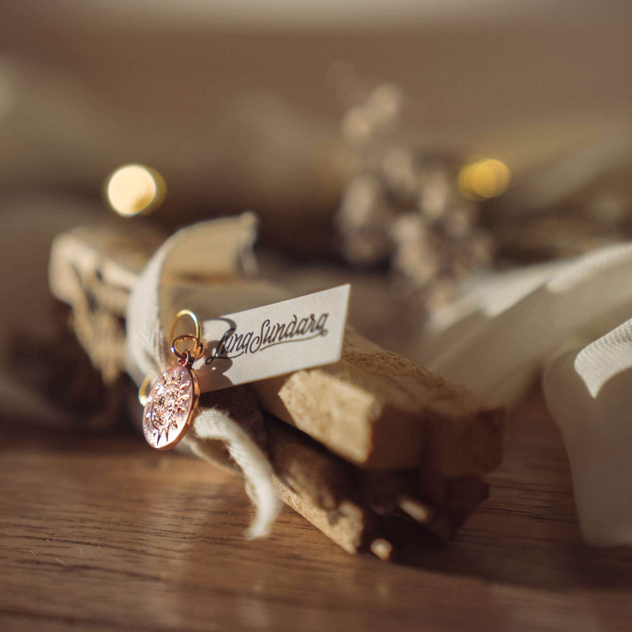 Palo Santo and Palma Dulce bundle on table bound with cotton ribbon and tag.