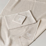 Beige towel set with 'MOKU' branding on a light gray background